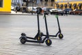 Black electric scooters parked outside for self use