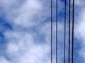Black electric wires on a background of a cloudy blue sky Royalty Free Stock Photo