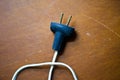 Antique cord with electrical plug lays flat on an old wooden table