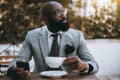 A black elegant guy in a street cafe