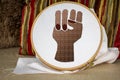 Black embroidered raised power fist on sewing hoop, activism through craft, craftivism, black lives matter, feminism, senior women