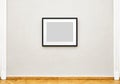 Black empty painting frame hanging on exhibition wall