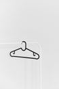 Black empty plastic hanger on the white rack isolated at the white background Royalty Free Stock Photo