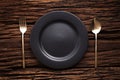 Black empty plate fork spoon on wooden table background Royalty Free Stock Photo