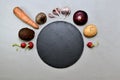 A black empty round substrate in the center half above is surrounded by a frame of vegetables.