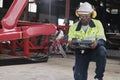 Black engineer test and control robotic arm in mechanical manufacturing factory