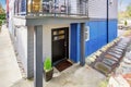 Black entrance door of modernized apartment with natural stone walkway.