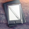 Black ereader with notebook and ink pen