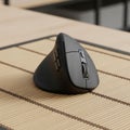 Ergonomic vertical computer mouse with a sleek design rests on a Royalty Free Stock Photo