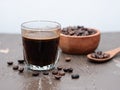 Black espresso coffee in a glass cup with coffee beans on a wooden table Royalty Free Stock Photo