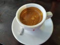 Black espresso coffee in a golden glass, eaten in a garden at home in Thailand, has a bitter taste, refreshing, very tasty.
