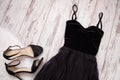 Black evening dress and shoes on a wooden background. Fashion concept. Top view Royalty Free Stock Photo