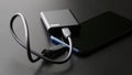 Black external portable SSD connected to a smartphone on a dark gradient background. Portable Solid State Drive. OTG interface. Royalty Free Stock Photo