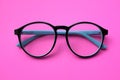 Top view Round black Eye Glasses on pink Background