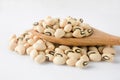 Black-eyed beans in wooden spoon on white background