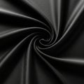 A black fabric with a smooth texture forms a spiral pattern, creating a sense of Royalty Free Stock Photo
