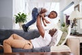 Black family, airplane and father with son on a sofa with love, lifting and playing in their home together. Flying Royalty Free Stock Photo