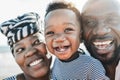 Black family on the beach - Mother, father and little son looking in camera and smiling - Main focus on kid eye