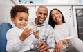 Black family, children and a boy playing with a toy car while his parents smile, sitting on the kitchen floor. Kids Royalty Free Stock Photo