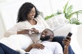 Black family couple relaxing on sofa, spending time at home. Royalty Free Stock Photo