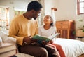 Black family, dad reading book to child for learning, support and language development, bonding in bedroom. Happy people Royalty Free Stock Photo