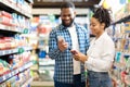 Black Family Doing Grocery Shopping In Supermarket, Using Phone Indoors Royalty Free Stock Photo