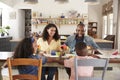 Black family of four having lunch in their kitchen at home