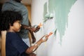 Black family painting house wall