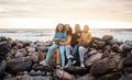 Black family, parents and children in beach portrait with excited face, sitting and rocks with happiness. Black woman