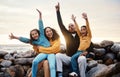 Black family, parents and kids in beach portrait with hands in air, sitting and rocks with celebration. Black woman, man