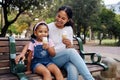 Black family, park and ice cream with a mother and daughter bonding together while sitting on a bench outdoor in nature Royalty Free Stock Photo