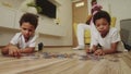 Black family in the room - brothers do a pazzle and only father playing with baby daughter