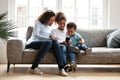 Mother and two kids together with laptop on couch Royalty Free Stock Photo