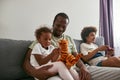 Black family spend time together on sofa at home Royalty Free Stock Photo