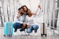 Black family of three traveling, taking selfie in airport