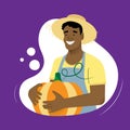 Cheerful dark-skinned farmer in a straw hat holds a large pumpkin in his hands on a purple background Royalty Free Stock Photo