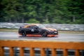 Black fast sports japanese car drives along a racing circuit.