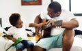 Black father enjoy playing guitar with his child together happiness Royalty Free Stock Photo