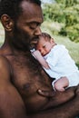 Black father holding his sleeping mixed race baby boy close Royalty Free Stock Photo