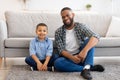 Black Father And Son Posing Sitting On Floor At Home Royalty Free Stock Photo