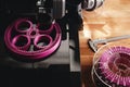 Black FDM-printer makes planetary gear machine part with visible infill from pink filament. Royalty Free Stock Photo