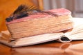 Black feather on old books on wood table reading for university school education