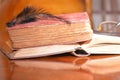 Black feather on old books on wood table reading for university school education