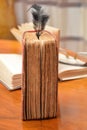 Black feather on old books on wood table reading for university school education