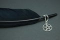 Black feather quill and pentacle necklace Royalty Free Stock Photo