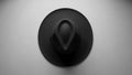 A black fedora hat is centered on a plain, light gray background Royalty Free Stock Photo