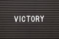 Black felt letter board with white alphabet in word victory background