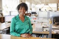 Black female architect in open plan office smiling to camera