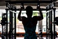 Black female athlete performing an upper body strengthening exercise by completing a pull-up