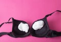 black female bra with cotton wool inside on a pink background. The concept of augmentation of the female breast with Royalty Free Stock Photo